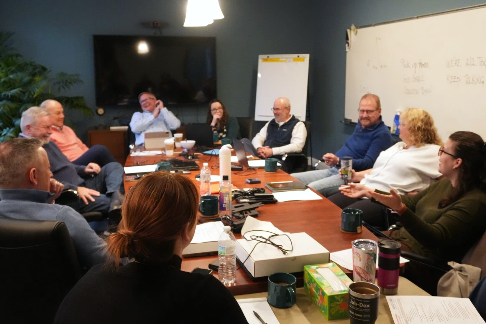 Violand team sitting around a table laughing during a meeting
